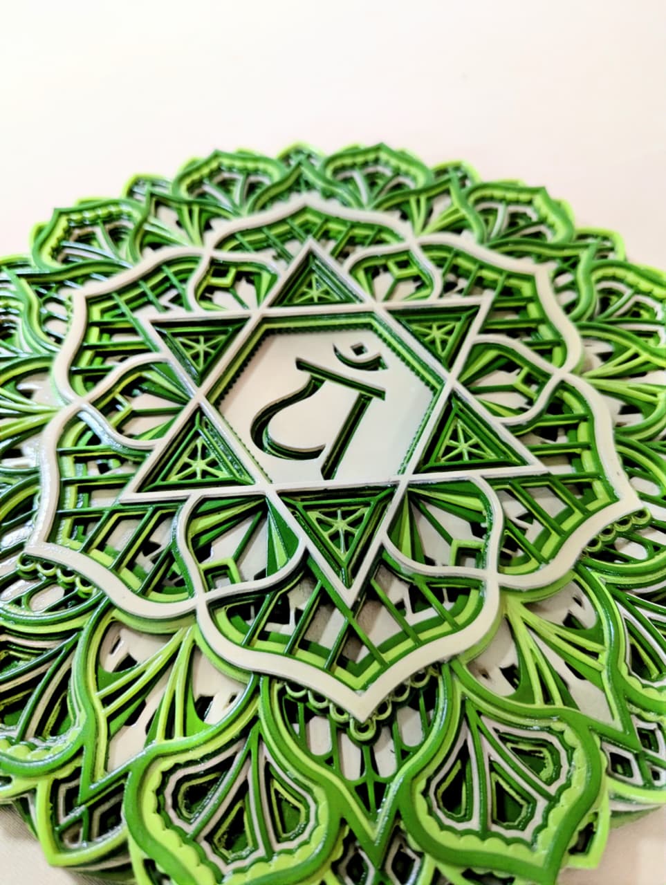 Intricate laser-cut Anahata chakra mandala detailing on wooden wall art