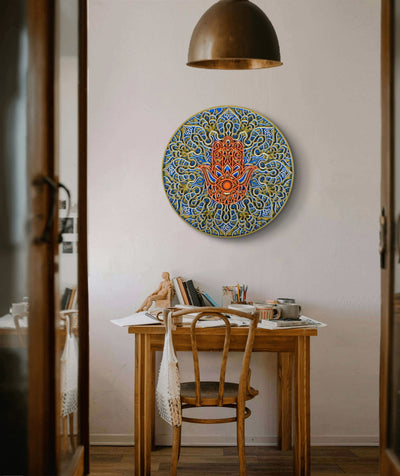 Decorative wall art above a wooden table in a room with a lamp and books.