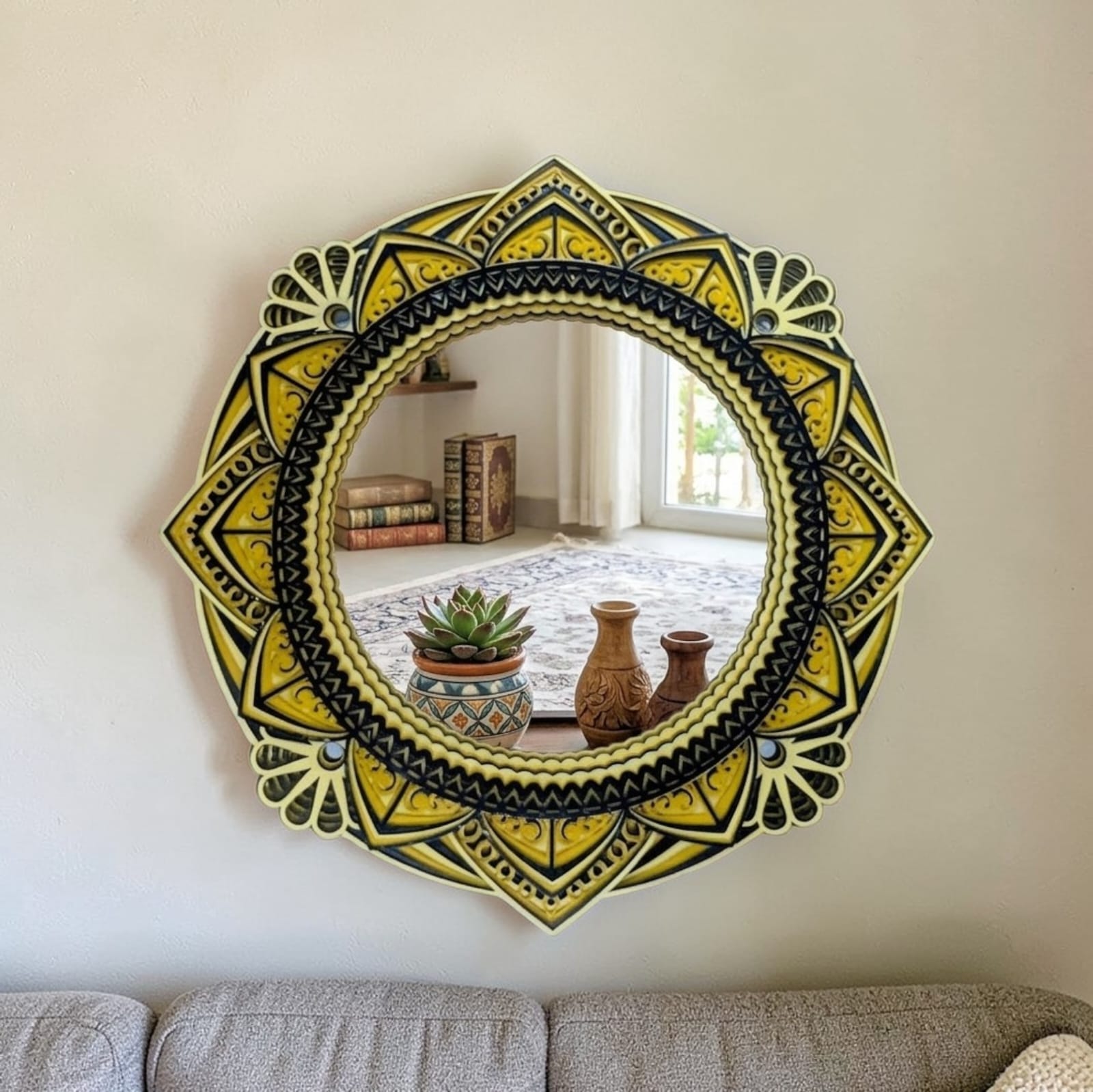 Decorative round mirror with yellow and black patterns on a wall above a sofa.